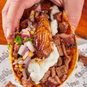 Mouth-watering taco with flavorful beef, salsa, and onions, captured in Monterrey, Mexico.