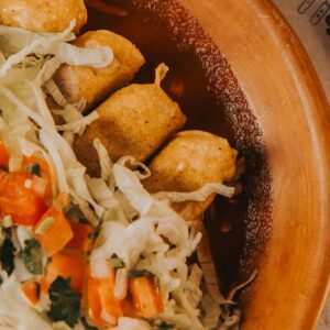 A vibrant plate of Mexican enchiladas topped with fresh lettuce and salsa, perfect for a cultural dining experience.