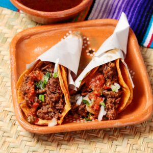 Savor the authentic Mexican tacos filled with spicy beef and vegetables, served with red sauce.