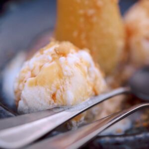 A close-up shot of fried ice cream topped with a crisp cone in a restaurant setting.