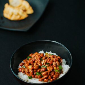 Asian rice bowl with flavorful beans on dark background.