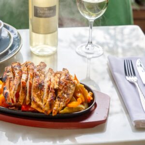 Tempting grilled chicken served with white wine on a sunlit table, perfect for a culinary delight.