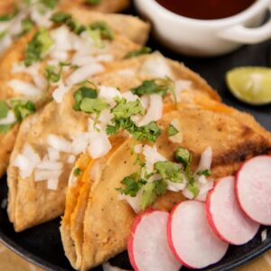 Delicious traditional Mexican tacos garnished with cilantro and onion served with fresh salsa.